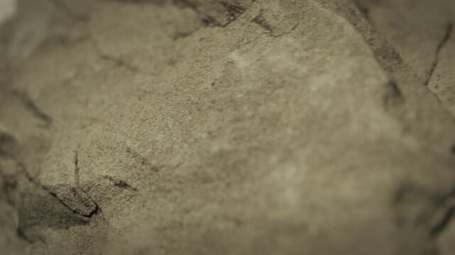 Rock texture video loop background, rotating and showing its rough surface. Grunge material macro loop, revealing a tough and dangerous nature