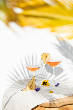Two rose wine glasses with summer cocktails and dried fruit appetizers