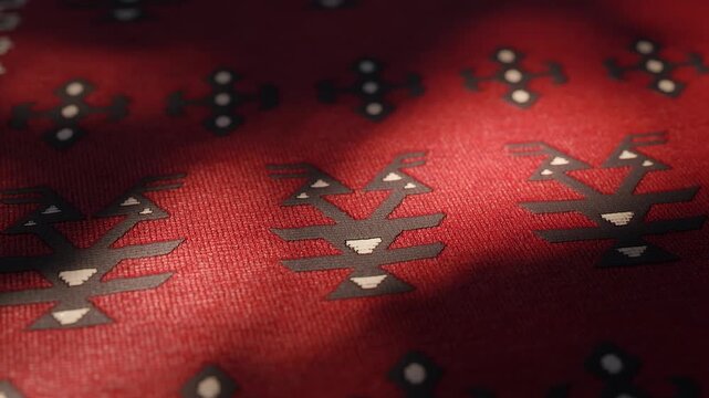 Close-up shot of an Albanian rug with traditional pattern covered by leaf-light patterns