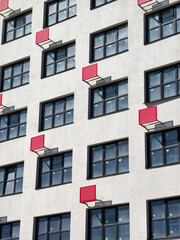 Obraz premium A newly built residential complex featuring red outdoor air conditioner brackets