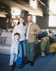 Naklejka premium Happy family shopping new sofa furniture store