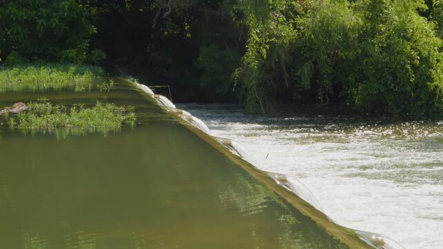 Water flowing over top of small Texas river dam