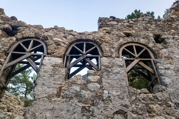 Obraz premium Ancient Roman ruins and stone aqueduct in Phaselis antique city, historical archaeological site remains with pine forest landscape and sunlight in Antalya, Turkey for travel and history concept