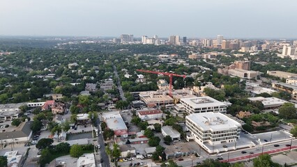 Fototapeta premium Aerial view of apartment complex under construction with large cranes attached.