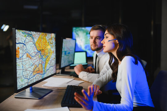 Control room workers managing logistics using digital maps