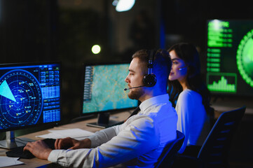 Air traffic controllers managing flights in control room © Serhii