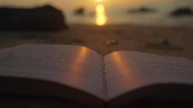 Open Book on Beach at Sunset With Golden Reflection and Calm Reading Atmosphere