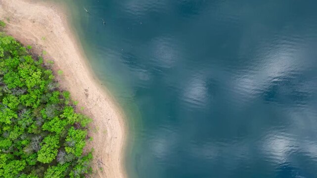 overhead view of dark water and sandy shoreline