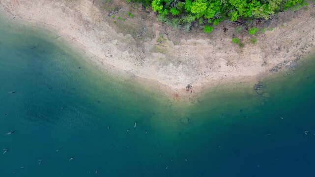 drone view of sandy shore and emerald water