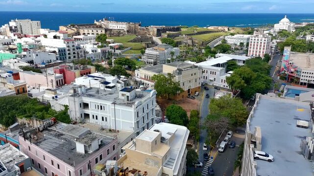 Drone video over old San Juan approaching Plaza Colon with San Cristobal castle on the background. 