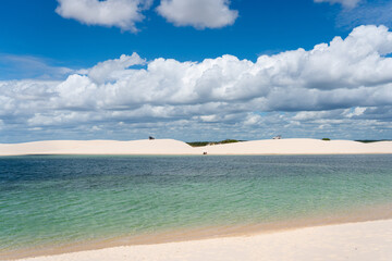 Fototapeta premium Paisagem dos Lençóis Maranhenses, no Maranhão, com lagoas naturais de água cristalina, dunas brancas, céu azul e formações de areia em um dos cenários mais conhecidos do nordeste do Brasil.