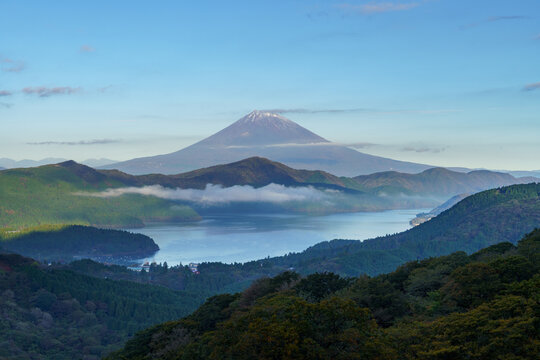 Stunning autumn landscape of Mount Fuji with fresh snow and sea of clouds over Lake Ashi in Hakone, Japan.