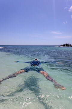 Man floating in glapagos, bay