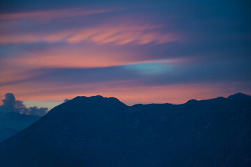 Obraz premium Tranquil Twilight Clouds Over Mountain Silhouettes. Dramatic Sunset Sky Above the Evening Landscape.