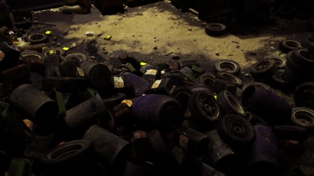 Assembled tires and emptied drums in dim exhibitionlike space, gritty textures and shadows create sculptural study for art, design or sustainability messaging.