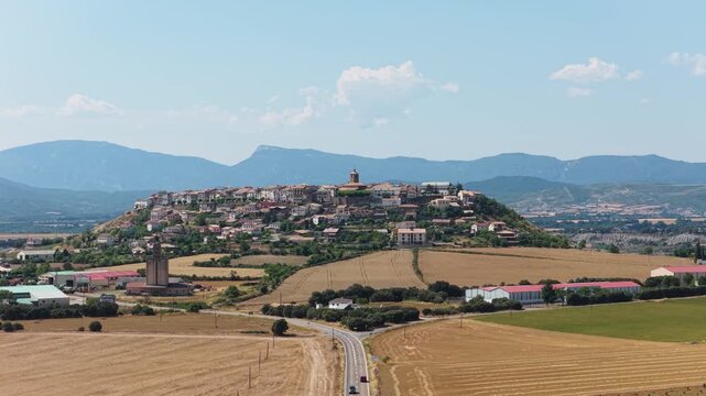 Panoramic view of the medieval town of Berdun situated on a hill. The Spanish village is surrounded by dry fields and mountains in summer