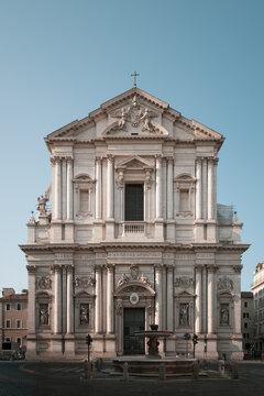 Church of Sant Andrea della Valle facade and fountain under clear blue sky in Rome, Italy. Beautiful baroque architecture of historic Roman basilica.