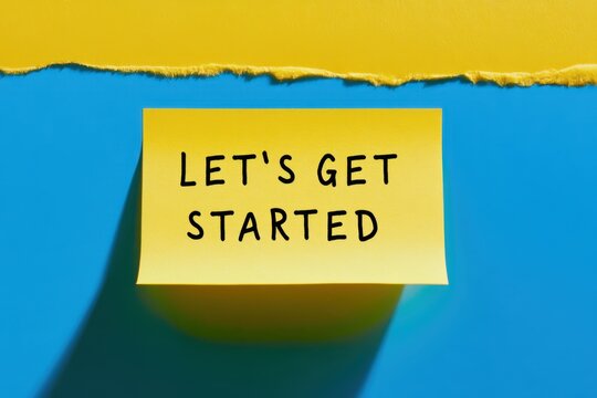 A yellow sticky note with the motivational phrase Let's Get Started on a blue and yellow background