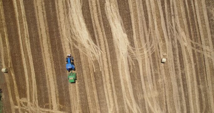 Tractor Baling Straw in Golden Agricultural Field Aerial View