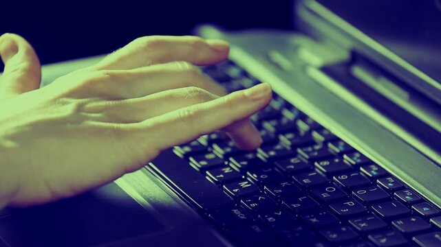 Business woman hands typing on a laptop keyboard. Online work, study, research, connection on pc. Closeup workspace with person fingers. Toned color
