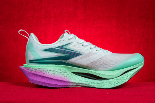 Zhongshan China-March 7 2026: 361&deg; white and green running shoes for boy on red.