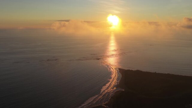 Aerial view of the Marino Ballena National Park's famous whale tail shaped sandbar at sunset. Golden hour light reflecting on the Pacific Ocean