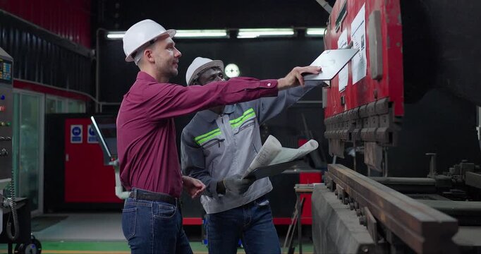 Sales Engineer Briefs Client on Machine Capabilities in Metal Workshop