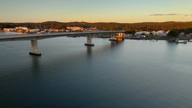 Aerial drone rising up view of Batemans Bay on the NSW South Coast, Australia, looking over Clyde River Bridge toward the CBD on a sunny early morning in May 2026   