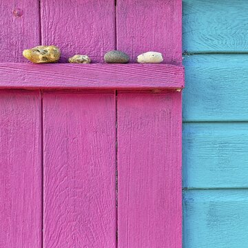 Four discarded stones on a beam, detail of a colourful wooden fa&ccedil;ade, pink, turquoise blue, England, Great Britain