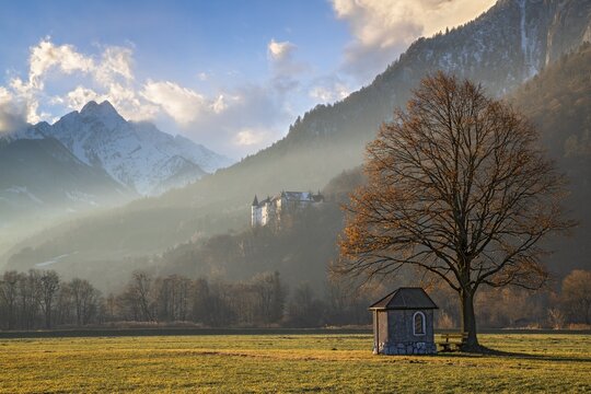 Small chapel under a tree, Tratzberg Castle and Fiechter Spitze in the background, Stans, Tyrol, Austria