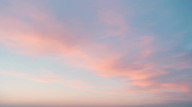 Soft pastel pink and blue clouds in a serene sky at sunset or sunrise