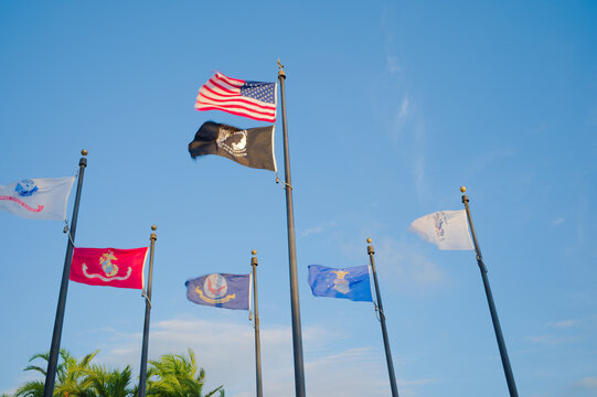 American Flag and Military Service Flags Flying Against Clear Blue Sky at Memorial Plaza Editorial Use Only May 23, 2026. Gulfport, FL USA. including POW/MIA and Marine Corps banners, flutter above a 