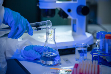 Fototapeta premium Laboratory scientist handling glassware involving liquids in a scientific research facility
