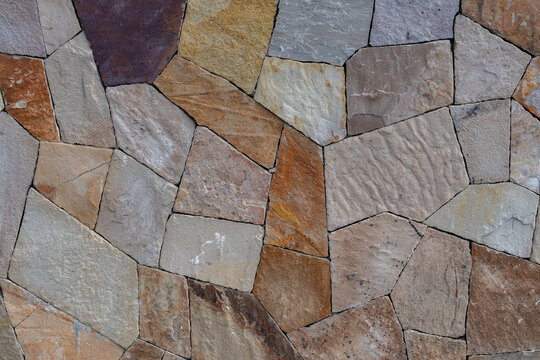 Muro de piedra laja de diferentes tonos y tama&ntilde;os con patr&oacute;n irregular.