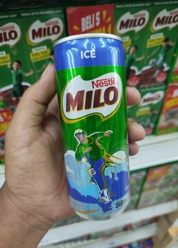 Kuala Terengganu, Malaysia - May 25. 2026: A person holding an aluminum slim can of Nestle Milo Ice chocolate malt drink in front of a supermarket product shelf.