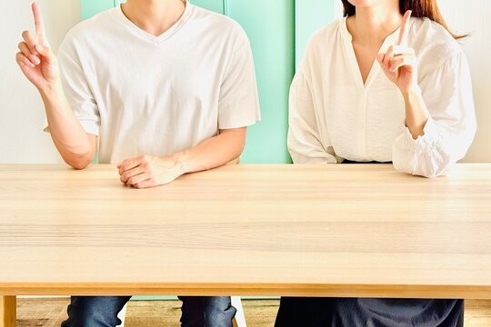 指を立ててアイディアを示す男女二人