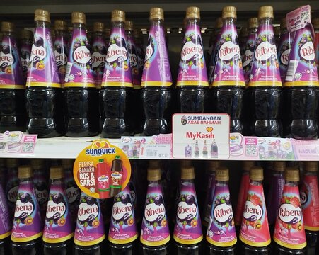 Kuala Terengganu, Malaysia - May 25. 2026: Multiple plastic bottles of Ribena blackcurrant and strawberry fruit cordial drinks neatly arranged on a supermarket shelf with promotional retail tags.