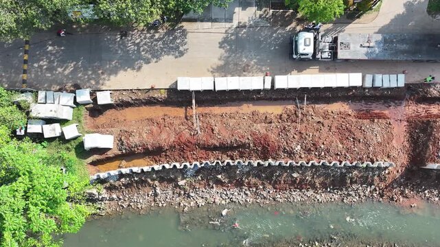 dredging mud on the riverbank in densely populated areas in the city center using heavy equipment such as excavators and dump trucks