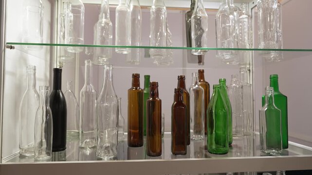 Clear Green Brown Glass Juice Beer Wine Bottle. Exhibition stand at the fair