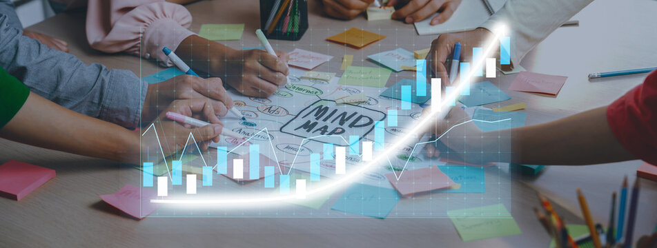 Engaging collaborative brainstorming session with diverse hands creating a colorful mind map while analyzing growth charts and graphs to visualize ideas. Axiom