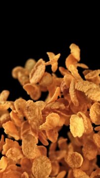 Corn flakes fly up and fall on a black background. Filmed on a high-speed camera at 1000 fps. High quality FullHD footage