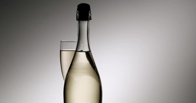 Effervescent bubbles gracefully rising in a flute of sparkling wine next to a bottle in a sophisticated and celebratory atmosphere, representing luxury, festivity, and fine dining.