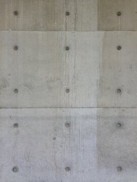close up of gray concrete wall with bolt marks