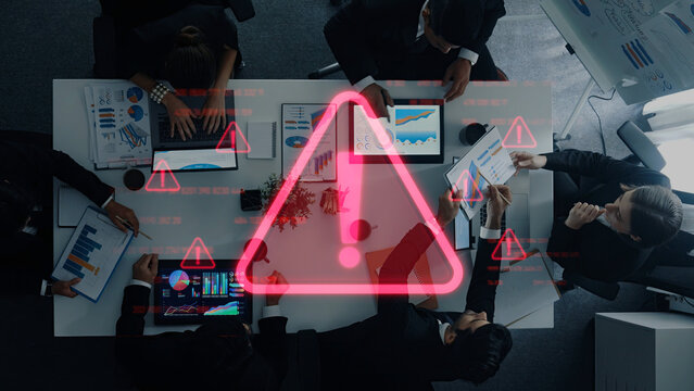 A group of business professionals engage in an important meeting, analyzing data on charts while warning symbols emphasize the need for immediate action and critical decisions. Trope