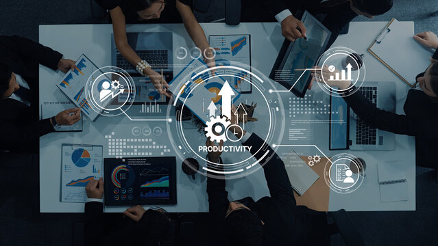 A dynamic business team collaborates in a modern office setting with digital interfaces, analyzing charts and graphs to enhance productivity and drive innovation. Trope
