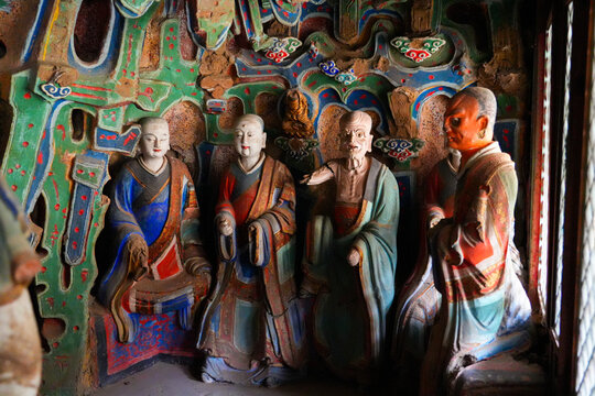 Ancient colorful statues of arhat disciples inside a scenic cave grotto at the suspended temple Xuankong Si near Mount Heng, Datong, Shanxi, China