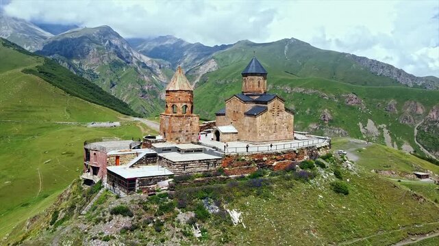 Aerial view of Gergeti trinity church perched on high mountain slope in georgia.