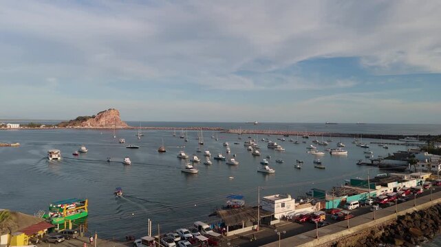 Vista oce&aacute;nica de la costa del Pac&iacute;fico mostrando yates y peque&ntilde;as embarcaciones ancladas en el mar calmado en el atardecer.