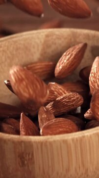 The almonds fall into a wooden bowl. Filmed on a high-speed camera at 1000 fps. High quality FullHD footage