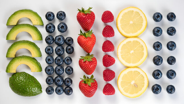 Top view of fresh fruits pattern with avocado, strawberries, lemons, raspberries and blueberries isolated on white background. Flat lay organic food background for commercial, textile and wallpaper de